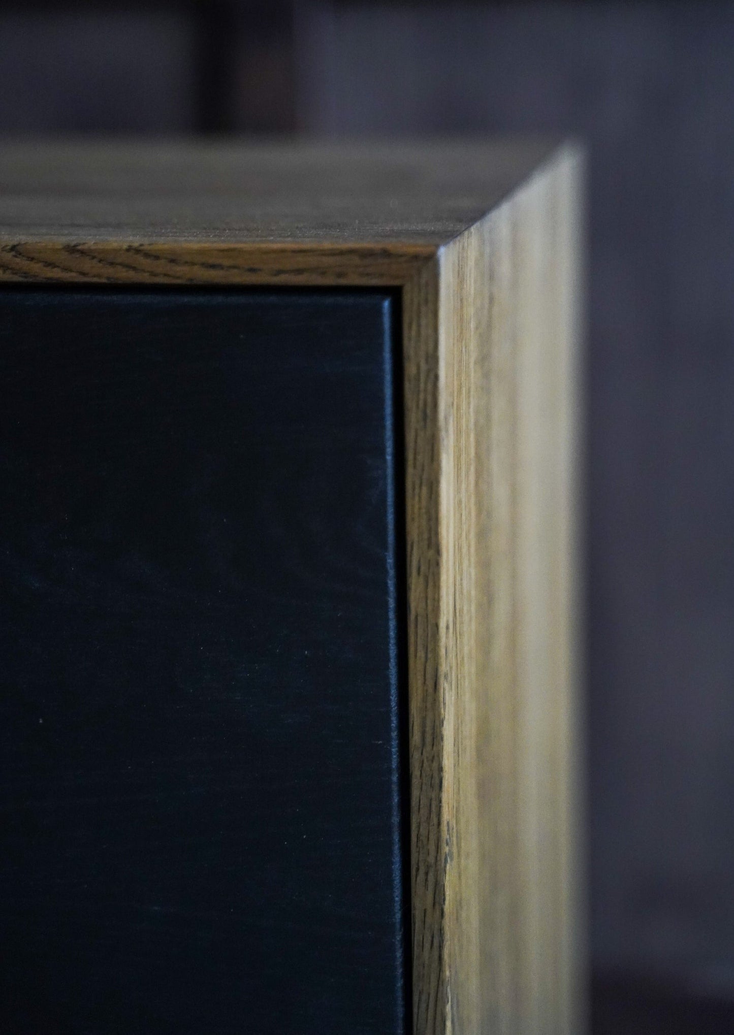 Skjenken Pilen kan brukes både som skjenk og kommode. Dørene og skuffefrontene er laget av naturlig eik. Rammen i naturlig eikefarge og de mørke skuffene skaper en elegant og unik kontrast.