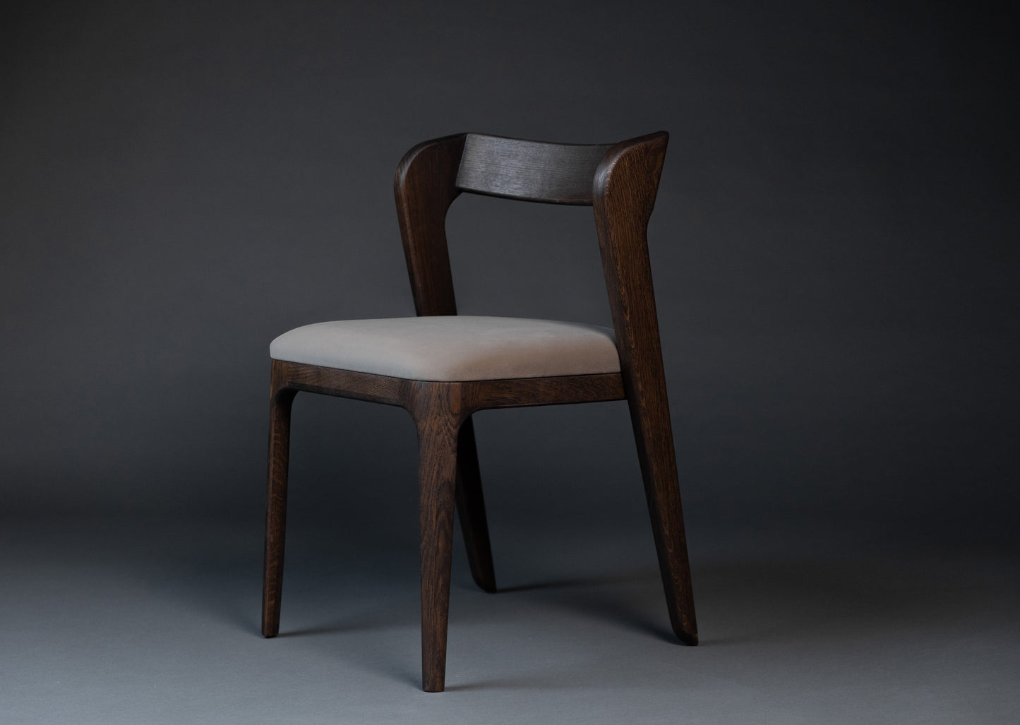 Stolen Vera er håndlaget i heltre eik som har et elegant eikmønster. Sittedelen er laget av tekstil.