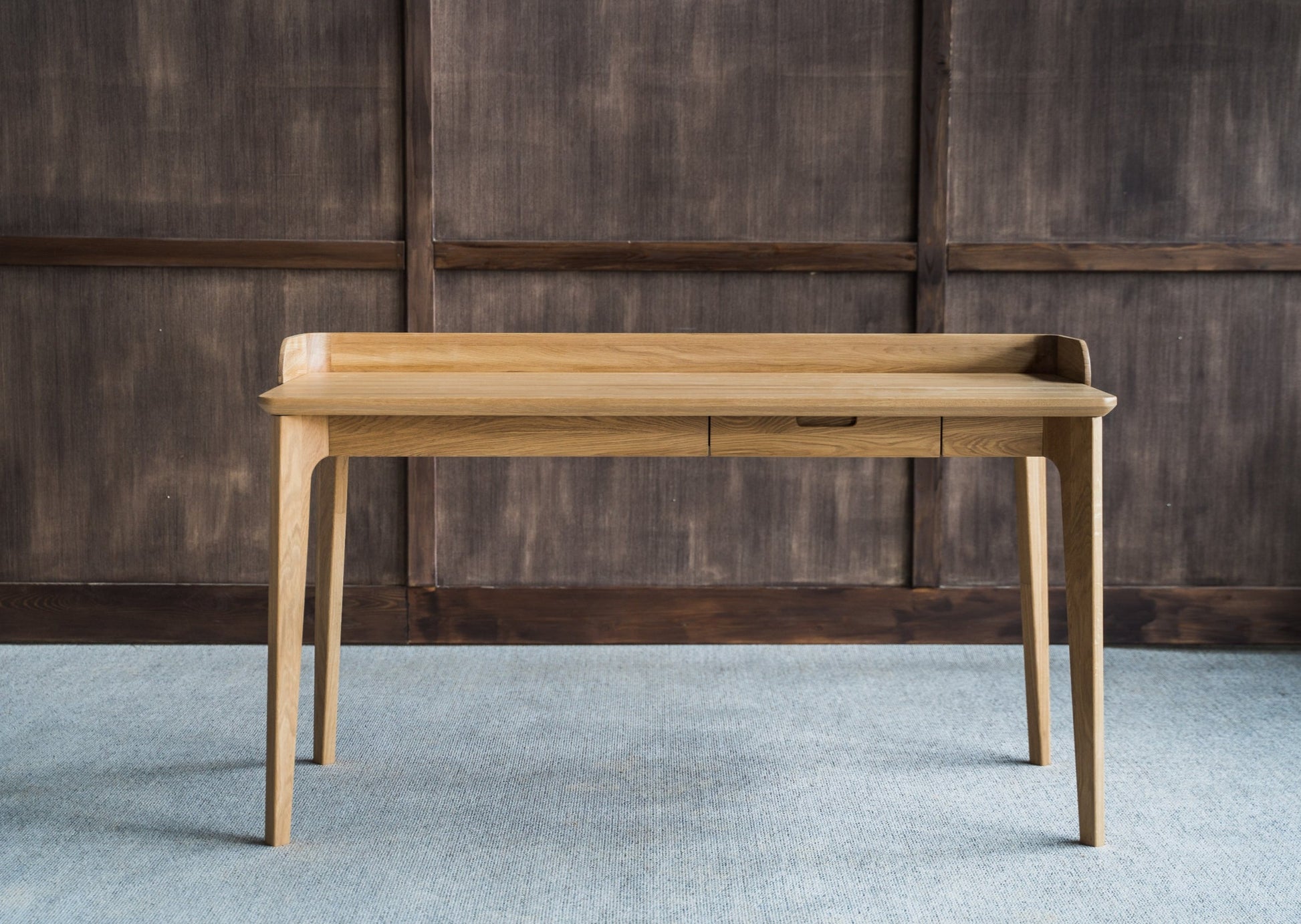 Skrivebordet Orion skiller seg ut med sin naturlige, tidløse og elegante design. Håndlaget skrivebordet i massiv eik med sin naturlige bordplate bringer frem treverkets karakter.