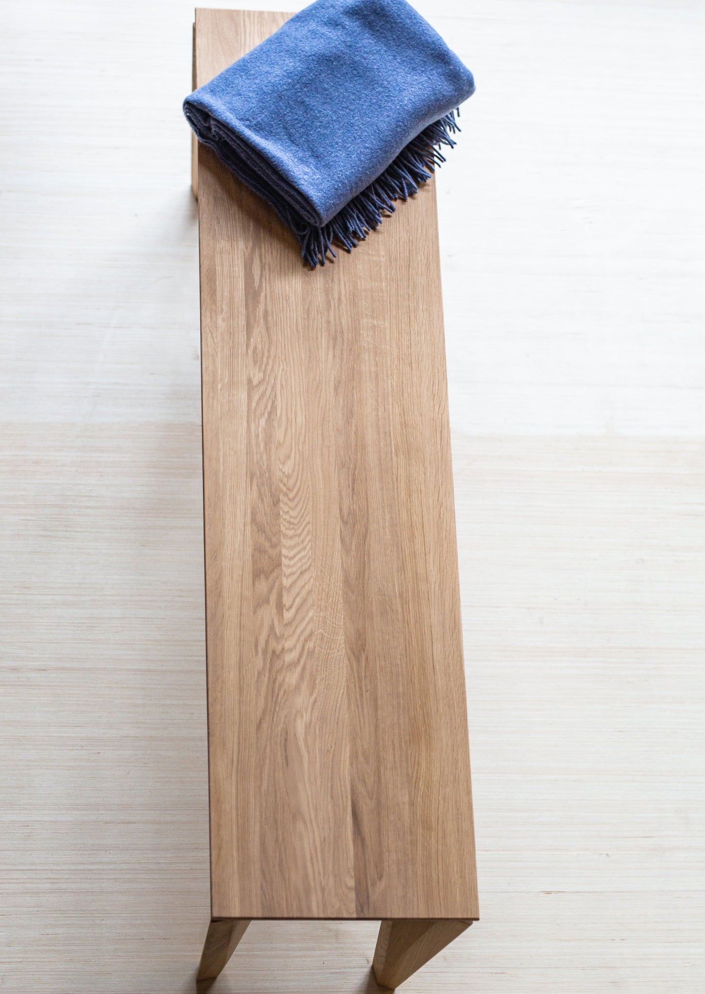 Sittebenken Peka er laget av høyeste kvalitet lys eik. Denne sittebenken har elegante og moderne former, med unike bein.