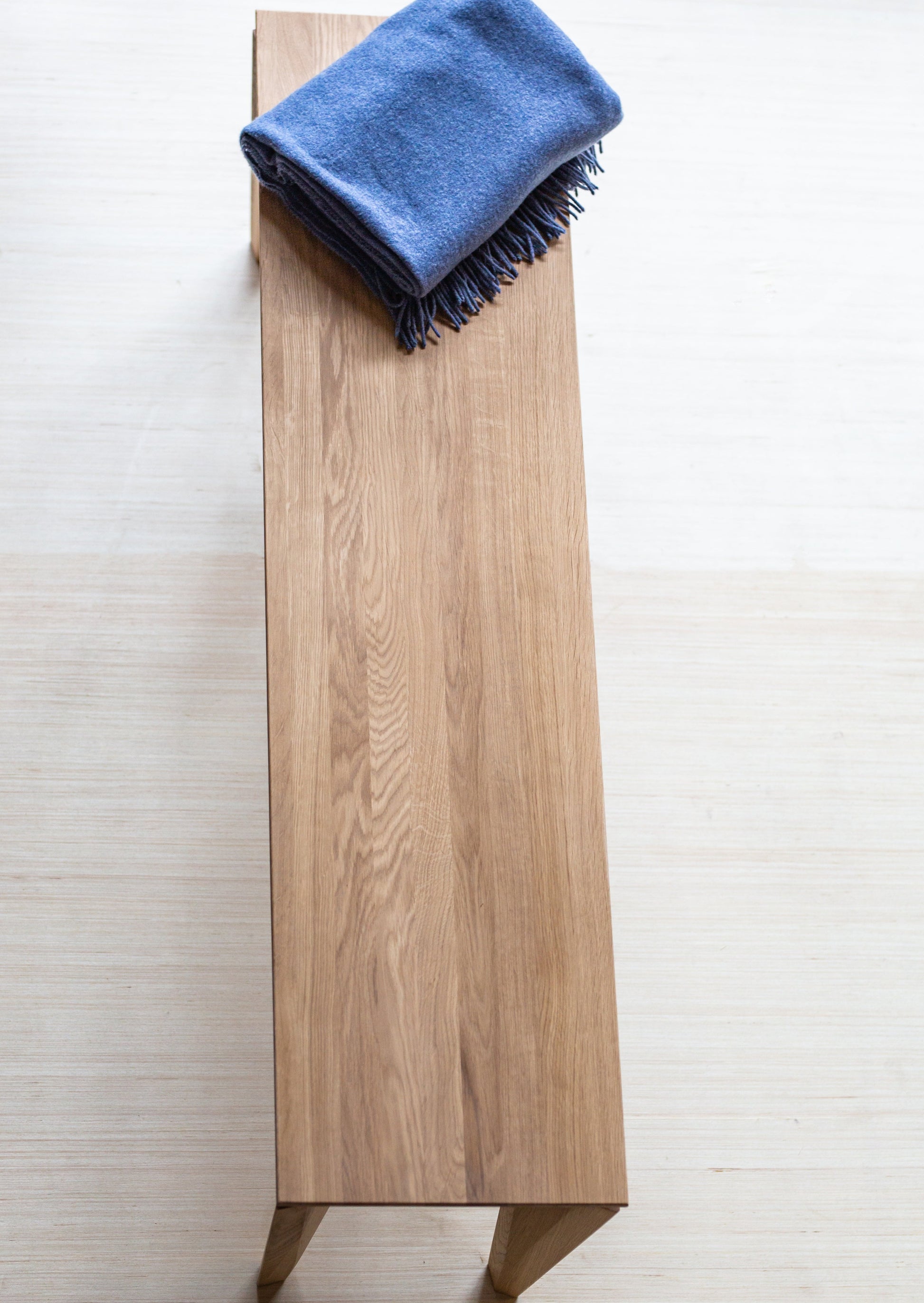 Sittebenken Peka er laget av høyeste kvalitet lys eik. Denne sittebenken har elegante og moderne former, med unike bein.
